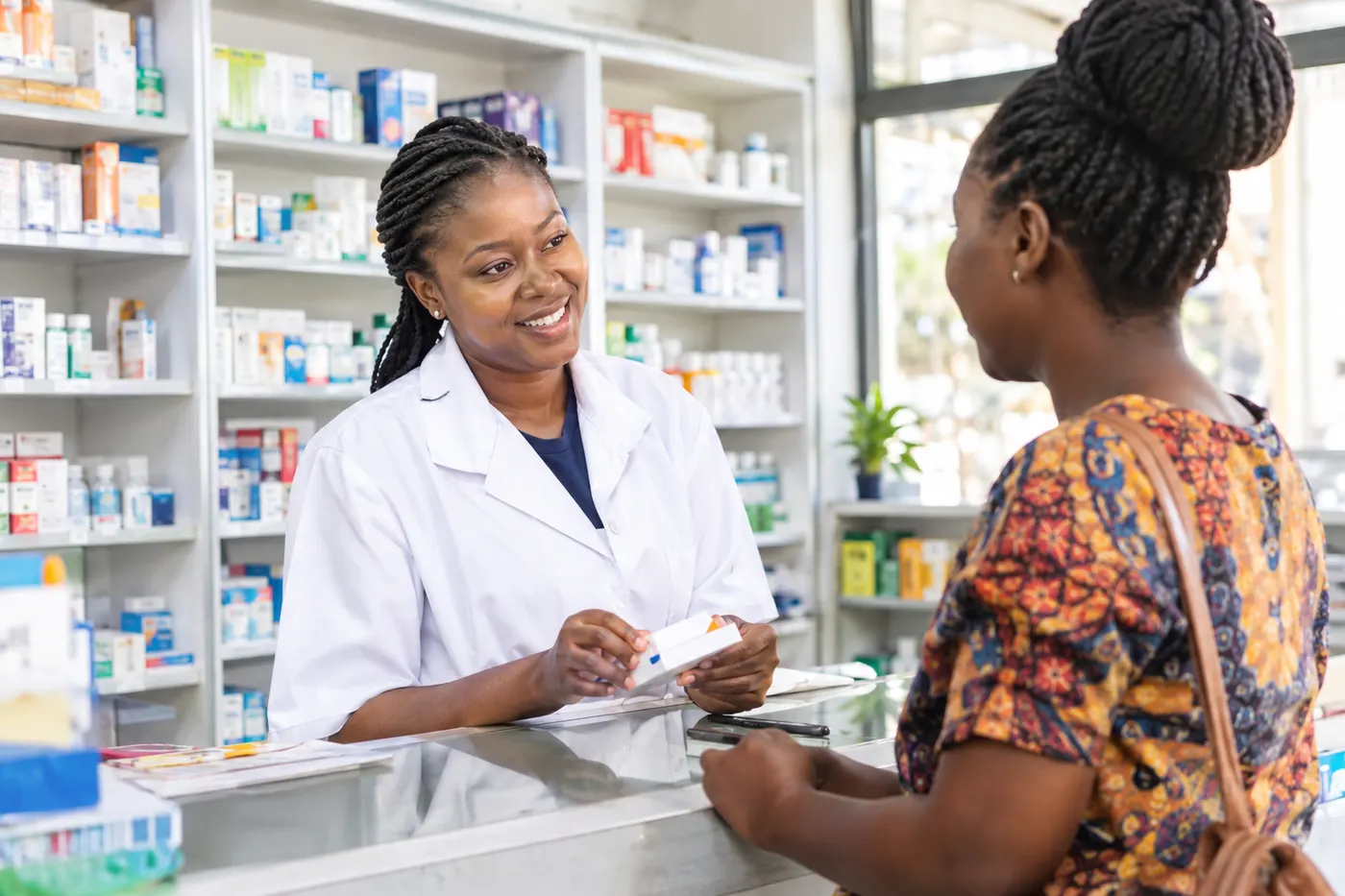 A pharmacist serving a customer at a bright pharmacy counter